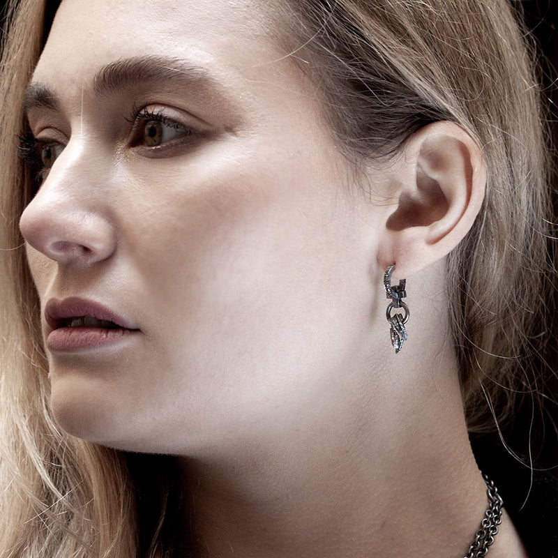 young blonde woman wearing a black silver and black diamond earring