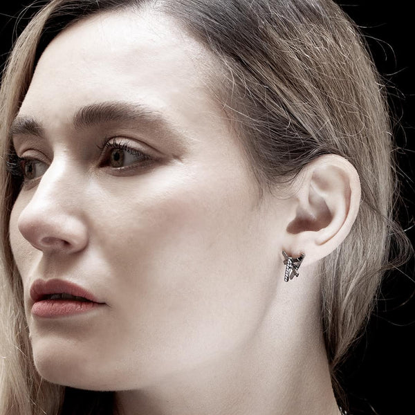 young woman wearing an anthracite gold earring with white diamonds