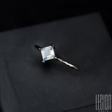 Side view of a white gold and square moonstone ring