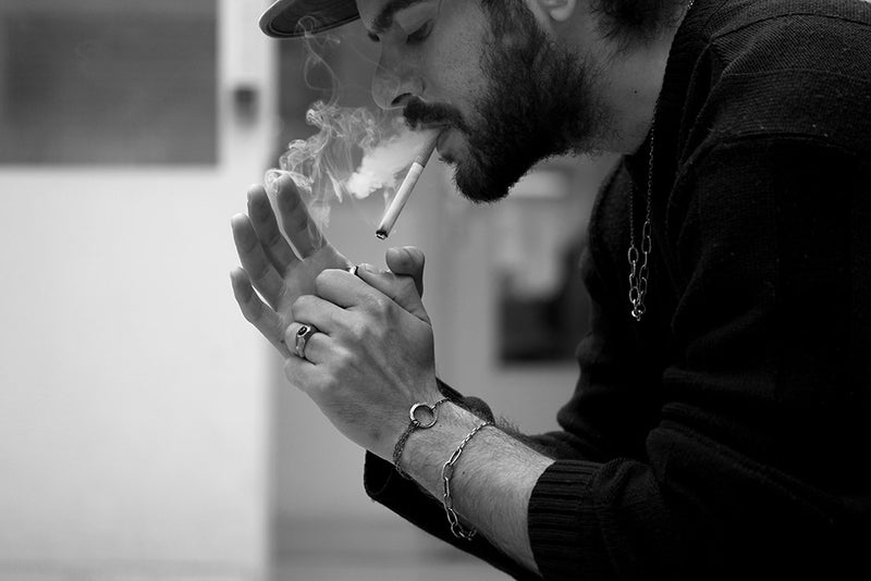 man smoking a cigarette wearing jewellery legion paris 