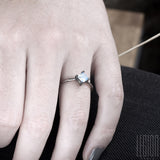 woman's hand wearing a white gold and square moonstone ring