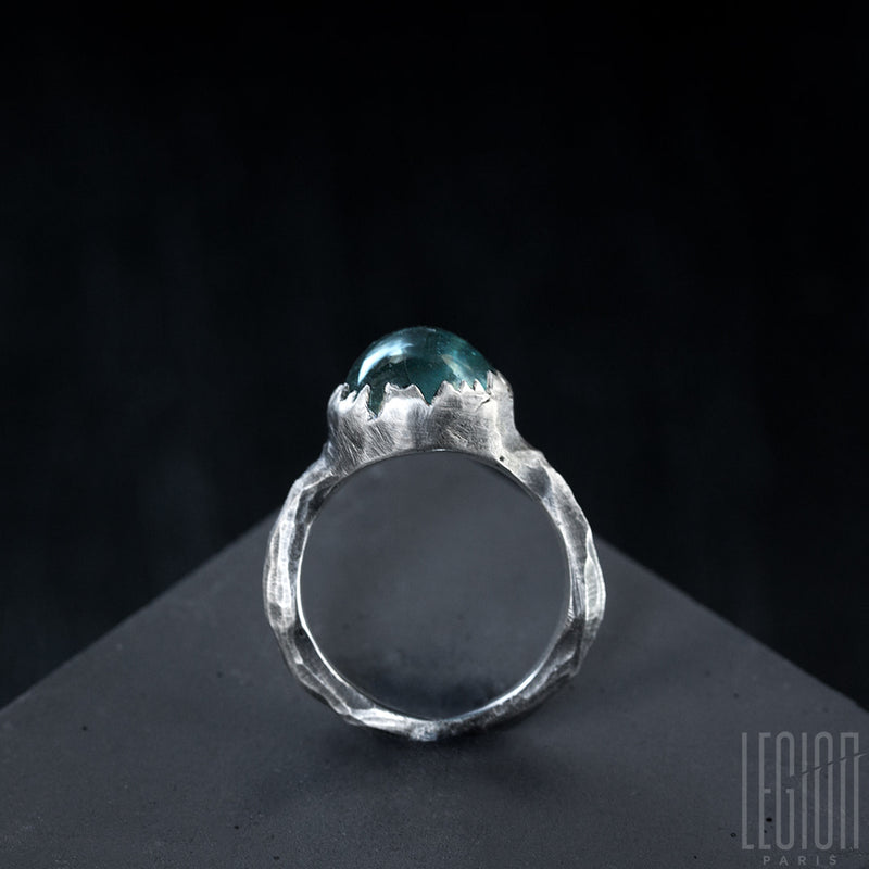 side view of a 925 silver Legion Paris ring with a serrated setting on a blue indicolite stone