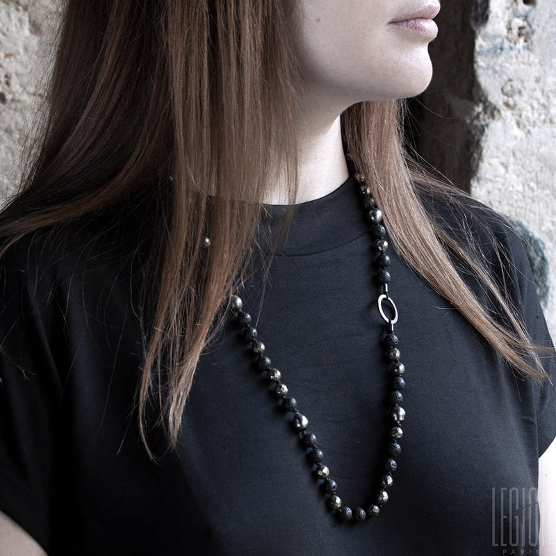 red-haired woman in a black T-shirt wearing a black pearl necklace