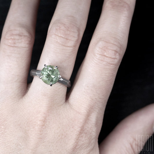woman's hand wearing a solitaire ring with an aquamarine