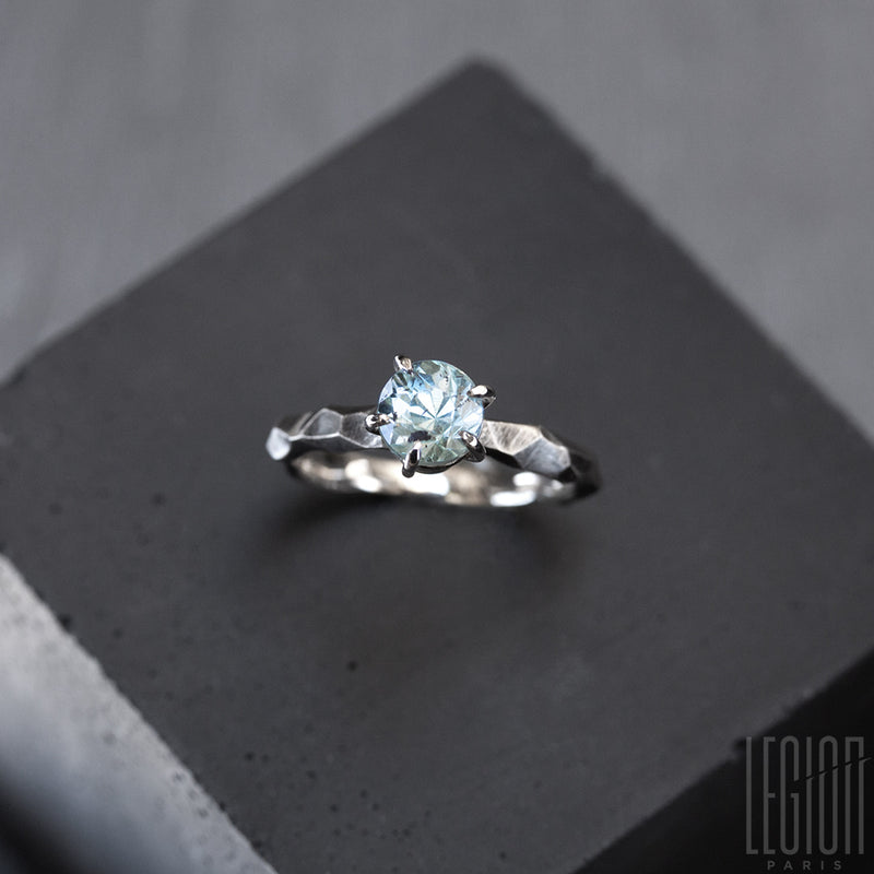 textured white gold solitaire ring with a blue aquamarine stone
