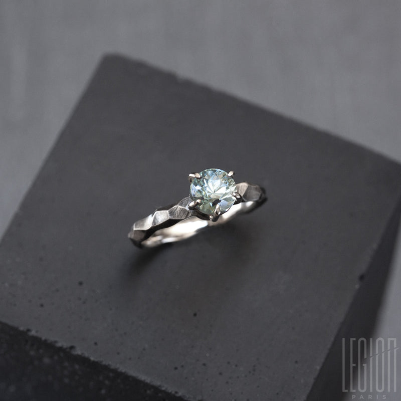 side view of a textured white gold solitaire ring with a blue aquamarine stone