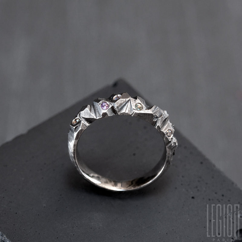 side view of a textured white gold ring with small light colored sapphires on top