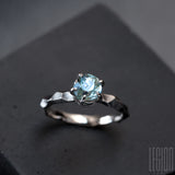 textured white gold solitaire ring with a blue aquamarine stone