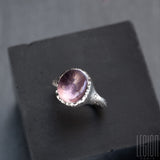 oval pink tourmaline stone mounted on a white gold ring with a tear drop setting
