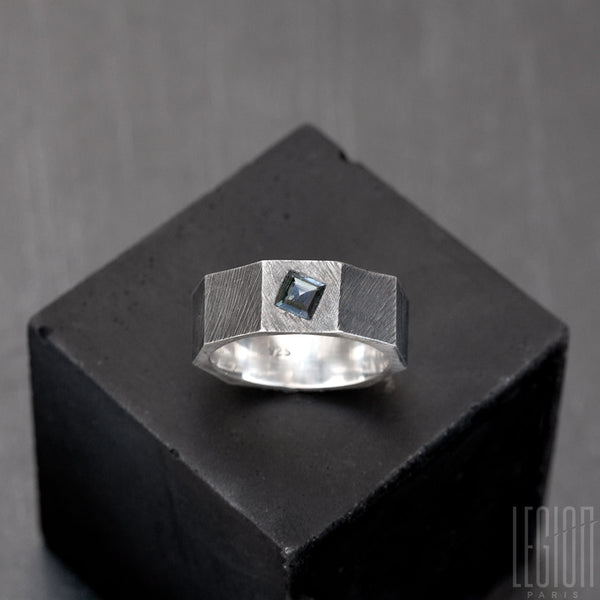 faceted ring, textured like a black silver nut with a square blue stone set in the metal