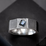 faceted ring, textured like a black silver nut with a square blue stone set in the metal