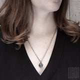 redheaded woman wearing a black tee shirt with a bear head pendant in black silver
