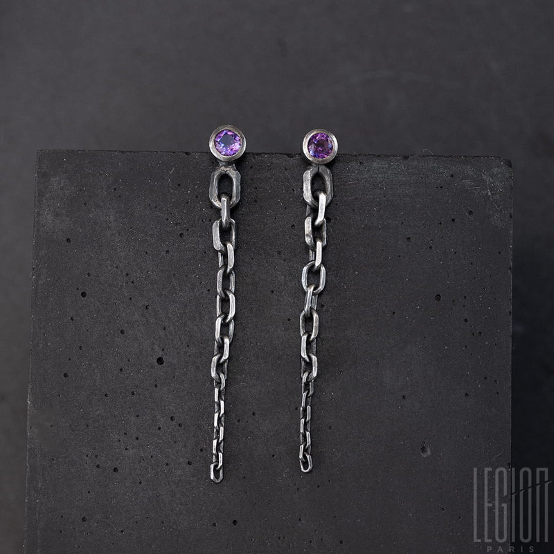 black silver earrings. each loop has a round purple stone set in closed. From this stone leaves a drop of chain in mesh forcat from the largest to the finest