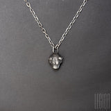 black silver pendant representing a bear head with two black diamonds in place of the eyes on a black silver diamond forçat chain