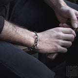 man's hands wearing a silver chain bracelet