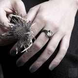 woman's hands wearing a black gold engagement ring with a rutilated quartz